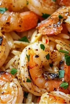 Plate of 15-minute garlic butter shrimp orzo with fresh herbs and lemon slices