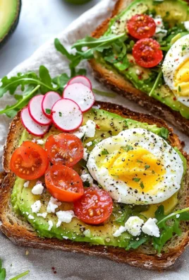 Delicious avocado toast topped with spices and herbs on a wooden board