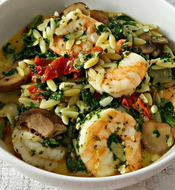 Delicious garlic orzo Tuscan shrimp dish served in a bowl.