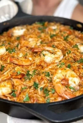 Greek Shrimp with Orzo Youvetsi dish garnished with herbs and spices