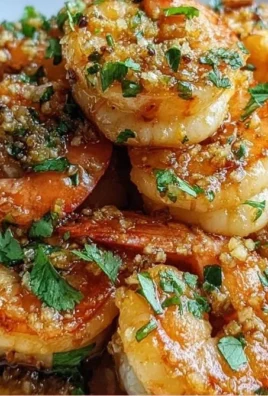 Delicious Hawaiian garlic shrimp served on a plate with herbs and lemon