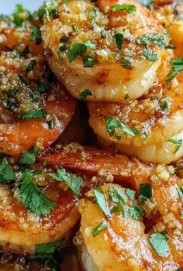 A plate of Hawaiian garlic shrimp garnished with herbs and lemon wedges