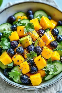 Juicy mango cucumber salad with blueberries and avocado in a vibrant bowl