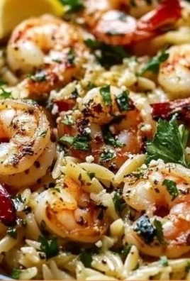 A vibrant dish of Lemon Feta Orzo Shrimp with herbs and lemon zest.
