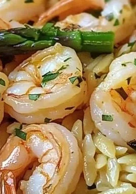 Plate of Lemon Garlic Shrimp with Asparagus Orzo garnished with fresh herbs