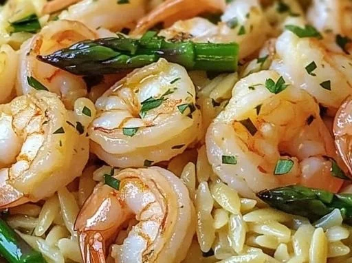 Plate of Lemon Garlic Shrimp with Asparagus Orzo garnished with fresh herbs