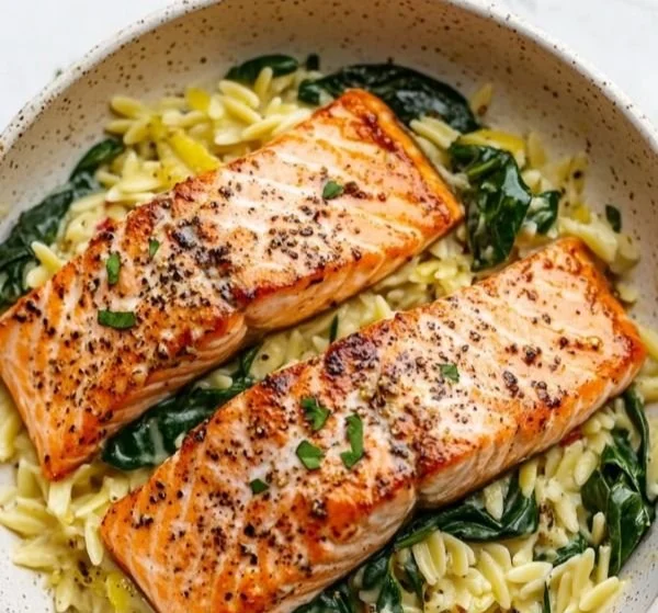 Plate of Mediterranean Salmon served with lemon orzo and fresh herbs