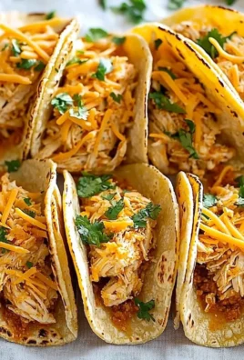 Mini baked chicken tacos on a plate, garnished with fresh toppings