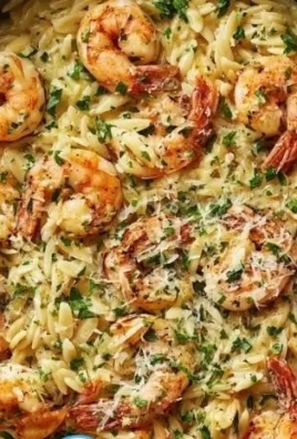 One pan dish featuring creamy Parmesan Orzo with shrimp, garnished with parsley.