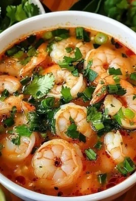 A bowl of quick and spicy shrimp soup garnished with fresh herbs.