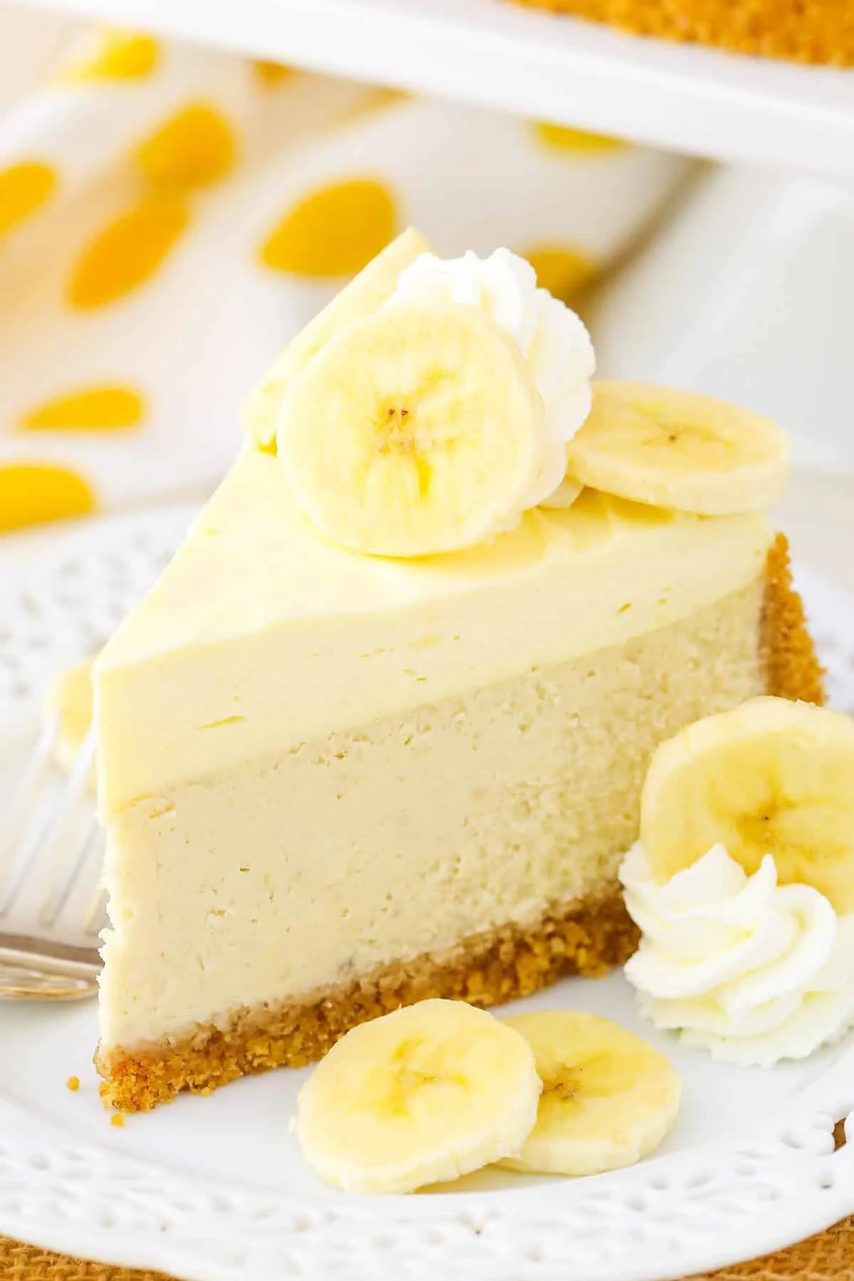 Slice of Banana Cream Cheesecake topped with banana slices and whipped cream