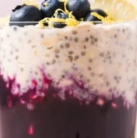Blueberry lemon overnight oats in a glass jar with fresh blueberries on top.