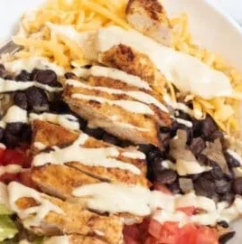 Tasty chicken burrito yumm bowl with fresh ingredients and vibrant colors.