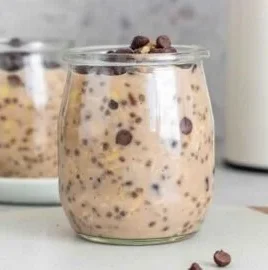 Bowl of chocolate protein overnight oats topped with fresh fruits and nuts