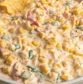 Delicious creamy corn dip served in a bowl with chips