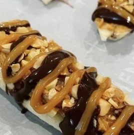 Frozen Healthy Snickers bars topped with chocolate and peanuts