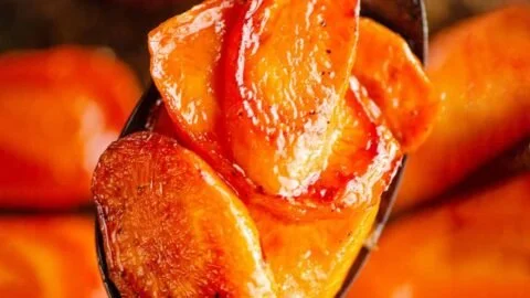 Plate of roasted hot honey carrots garnished with herbs