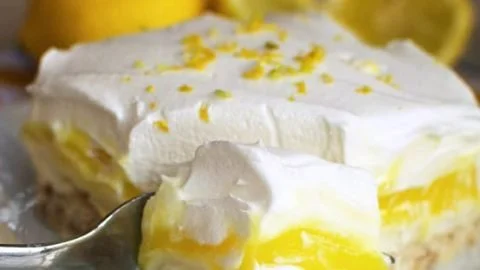 Delicious lemon lush dessert with whipped cream and lemon zest.