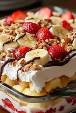 No-Bake Banana Split Cake topped with fruits and whipped cream