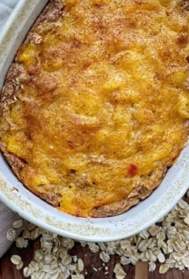 Bowl of Peach Baked Oatmeal topped with fresh peaches and nuts