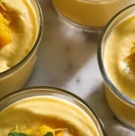 Delicious Pioneer Woman Mango Mousse dessert in a bowl topped with mint leaves.