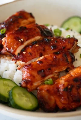 Sticky Honey Gochujang Chicken garnished with sesame seeds and green onions