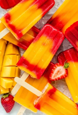 Homemade Strawberry Mango Popsicles in a sunny setting