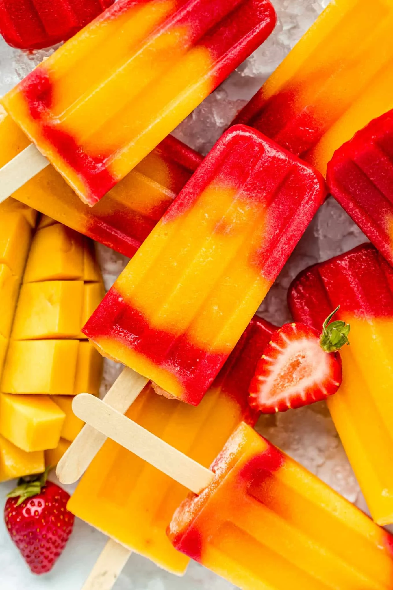 Homemade Strawberry Mango Popsicles in a sunny setting