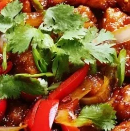 Delicious Sweet Chili Chicken served on a plate with fresh vegetables