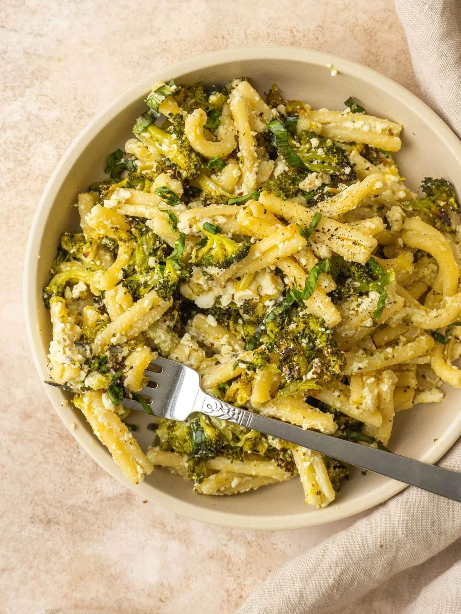Baked Feta and Broccoli Pasta served in a bowl, garnished with herbs.