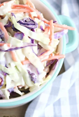 Bowl of classic coleslaw with carrots and cabbage, served as a side dish.