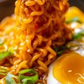 Creamy Buldak Cheese Ramen in a bowl, garnished with green onions and chili flakes.