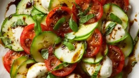 Cucumber Caprese Salad with mozzarella, tomatoes, and basil on a plate