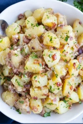 Delicious German Potato Salad with bacon and herbs on a plate.