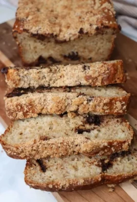 Delicious Greek Yogurt Banana Bread freshly baked and sliced on a wooden cutting board.