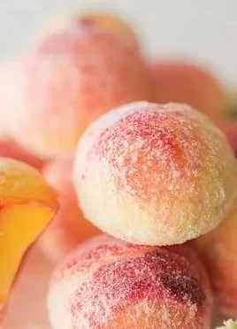 Italian Peach Cookies stacked on a plate with fresh peaches