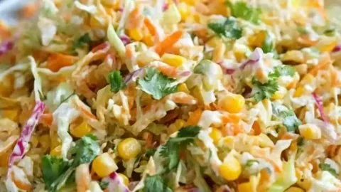 Bowl of spicy corn slaw with fresh ingredients and vibrant colors, perfect for summer meals.