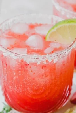 Strawberry Lime Mocktail Margarita in a glass with lime slices
