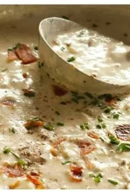 Bowl of creamy clam chowder with fresh ingredients and toppings