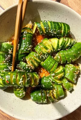 Bowl of Asian cucumber salad with colorful vegetables and dressing.