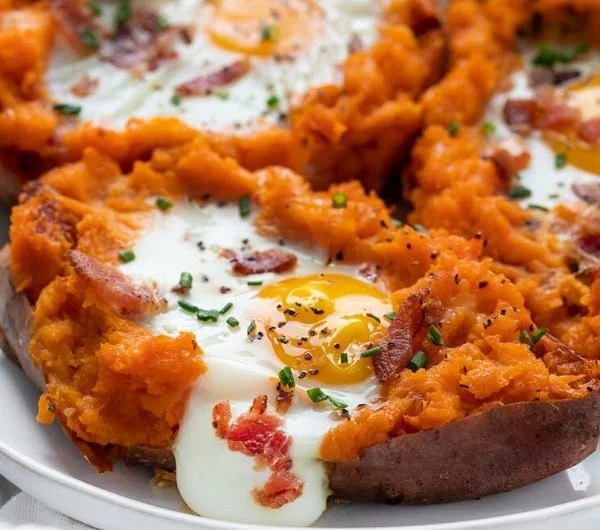 Delicious breakfast sweet potato topped with eggs and herbs