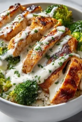 Chicken and broccoli bowls with creamy garlic sauce served in a rustic bowl.