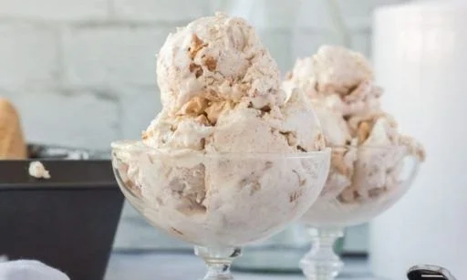 Cinnamon Toast Crunch ice cream scoop in a bowl with cereal pieces