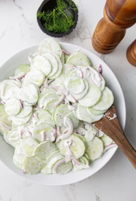 Creamy cucumber salad in a bowl showcasing fresh ingredients and vibrant colors.