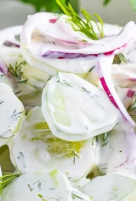 Creamy cucumber salad served in a bowl with fresh herbs and spices