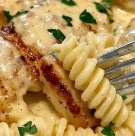 Creamy garlic butter chicken with rotini pasta in parmesan sauce served in a bowl