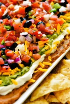 Delicious creamy layered dip served in a colorful bowl with chips