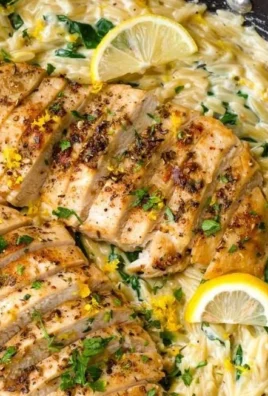 Creamy lemon chicken orzo dish garnished with fresh herbs