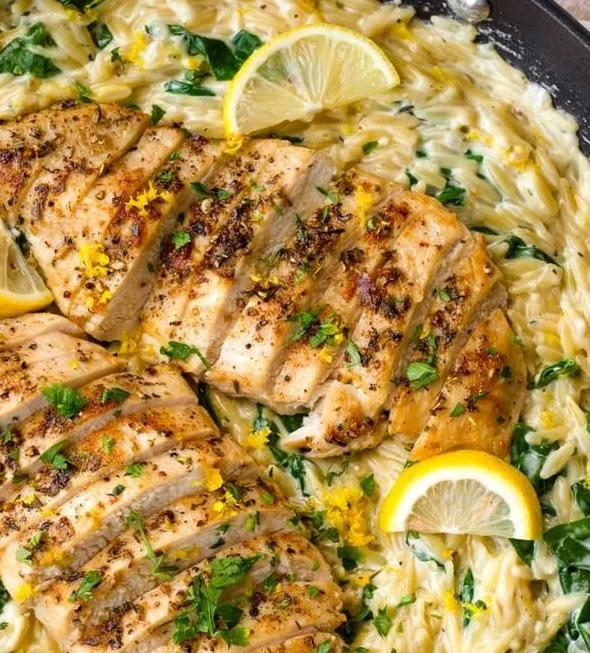 Creamy lemon chicken orzo dish garnished with fresh herbs
