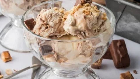 Bowl of homemade Snickers ice cream with chocolate and caramel toppings